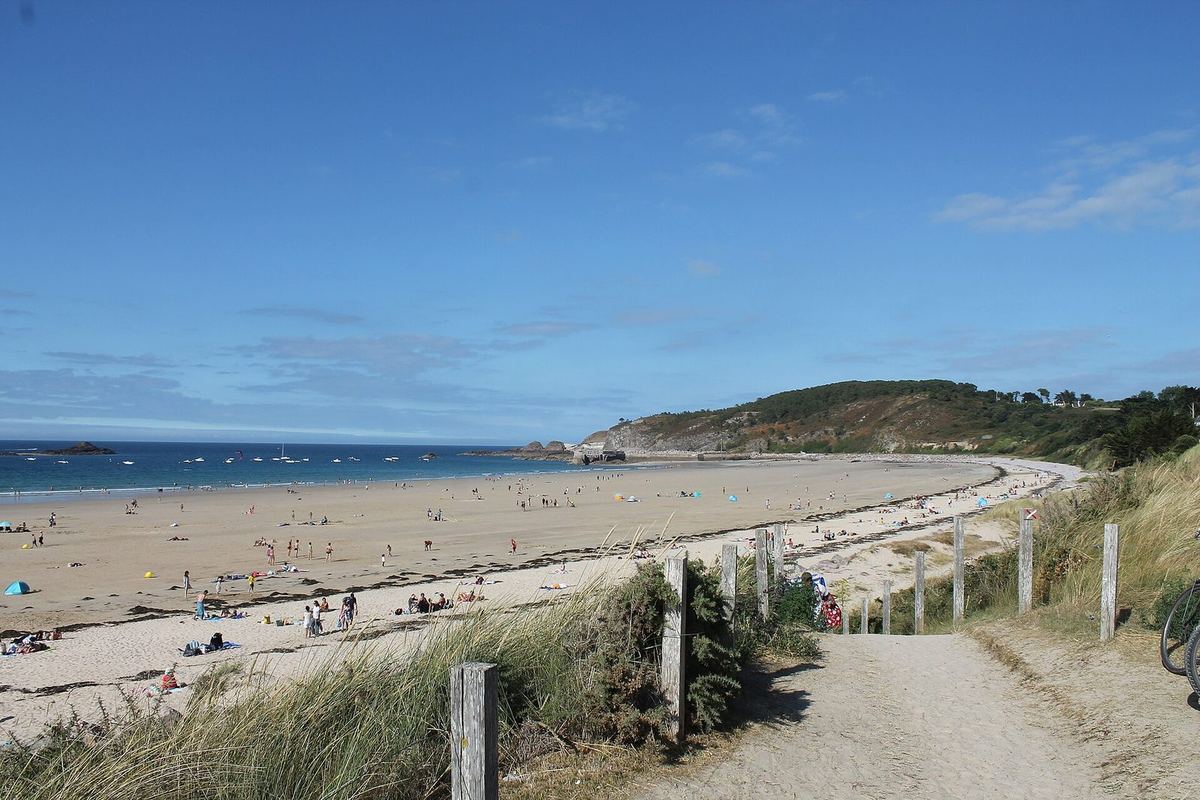 Sables-d'Or-les-Pins : un chemin descend entre les dunes vers une longue plage de sable clair